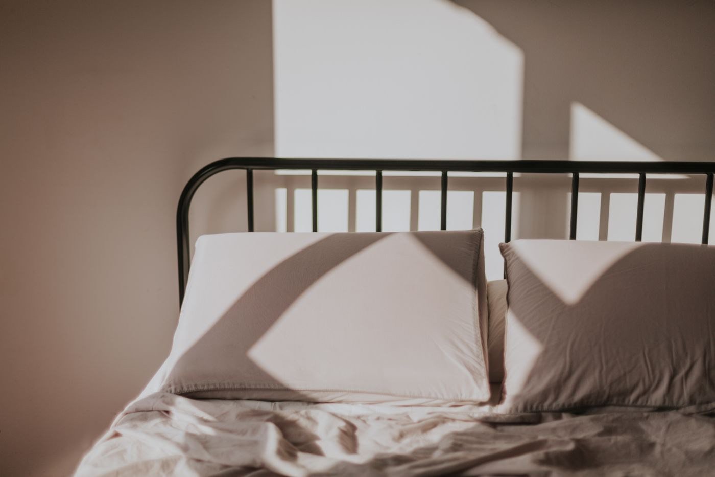 Una cama deshecha y vacía, con la luz de la mañana entrando por la ventana
